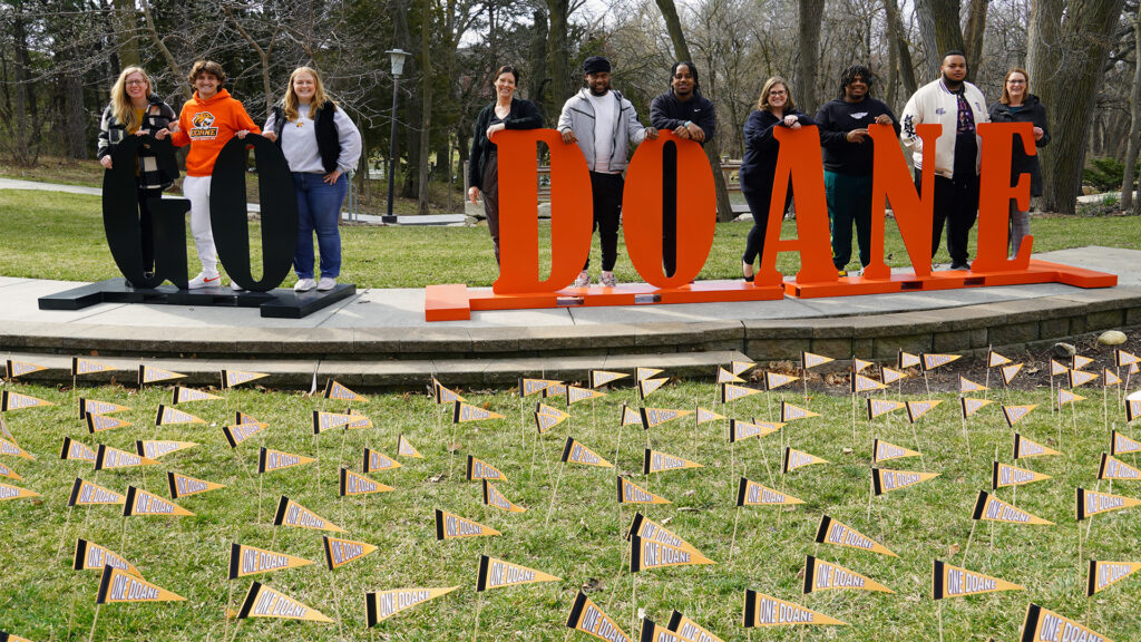 A group of staff members from the Advancement and Alumni Office pose alongside several Tiger students after nearly 700 orange pennants were placed in Cassel Theatre, one for every $200 raised in the campaign.