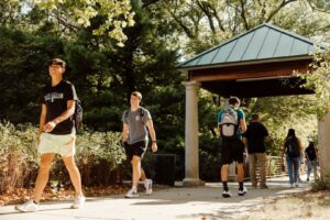 Students walking on path with covered pergola